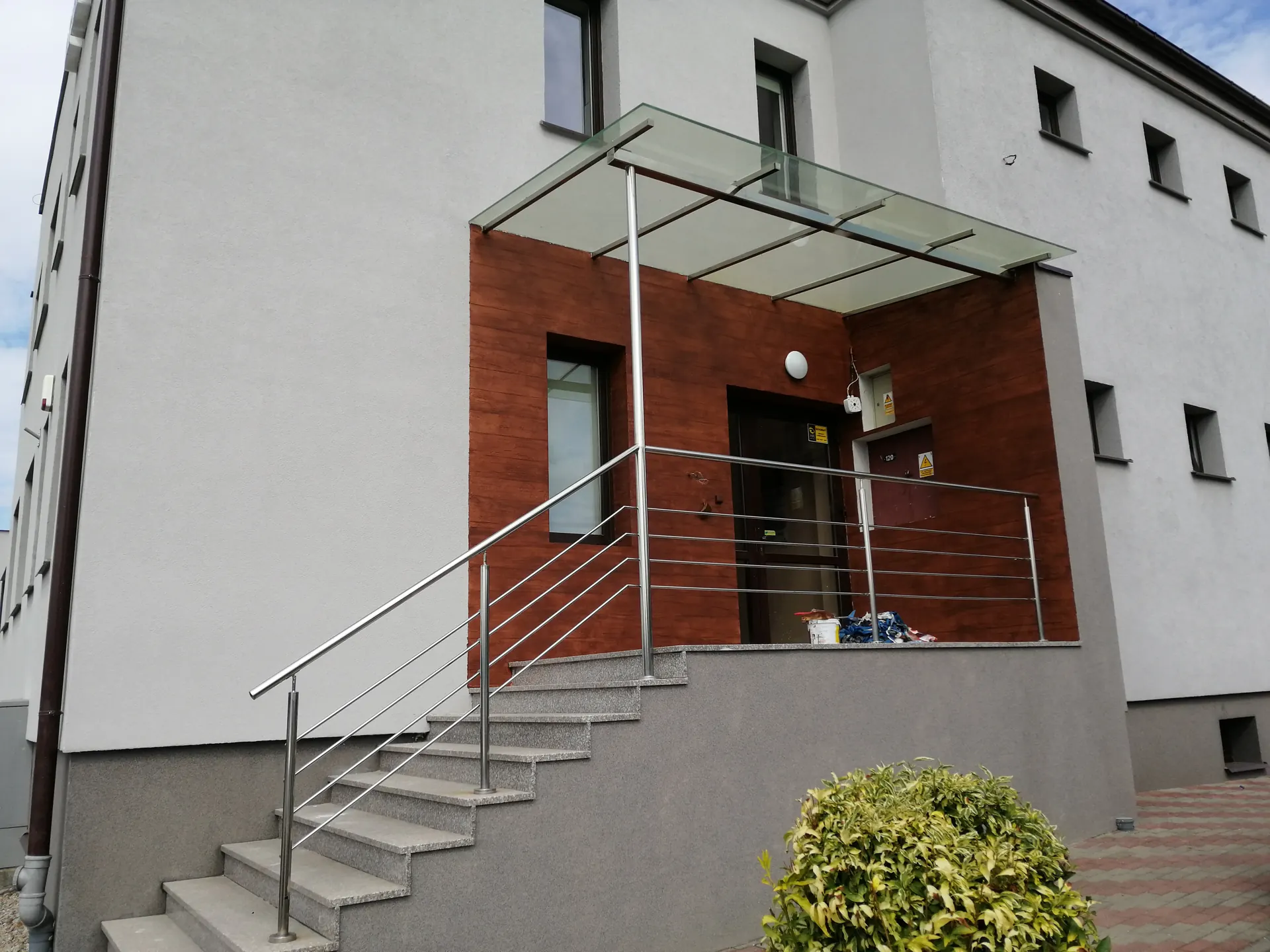 Wejście do budynku z zadaszeniem i balustradą